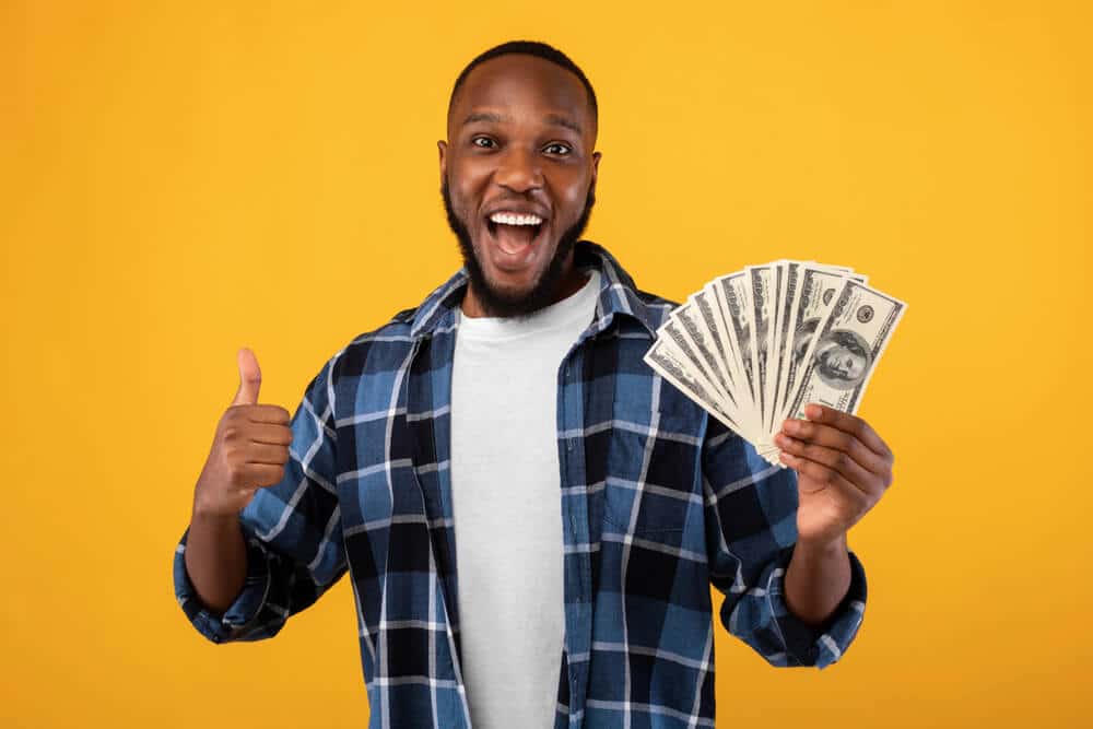 Man holding cash and smiling